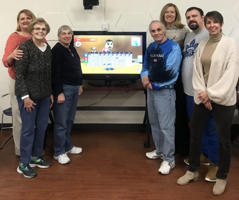 psl oakwood team Oakwood employees smiling next to TV