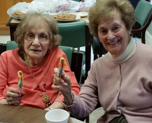 smiling women holding worry dolls