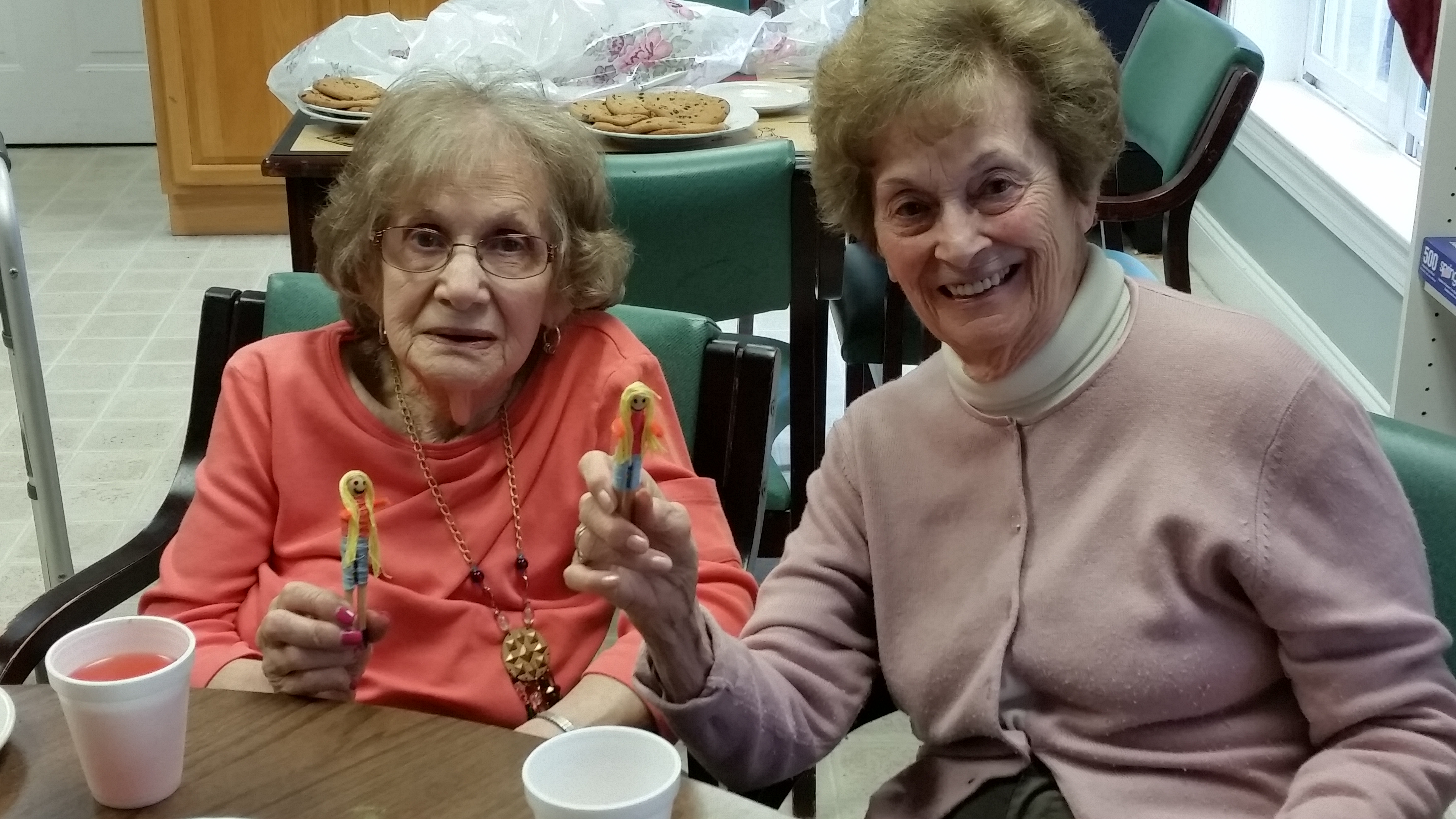 smiling women holding worry dolls