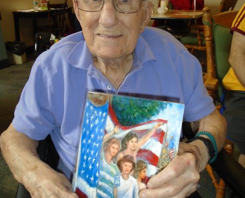 man holding painting of children waving american flag