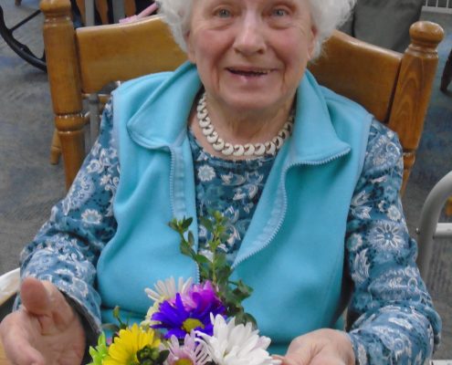 woman smiling with pot of flowers