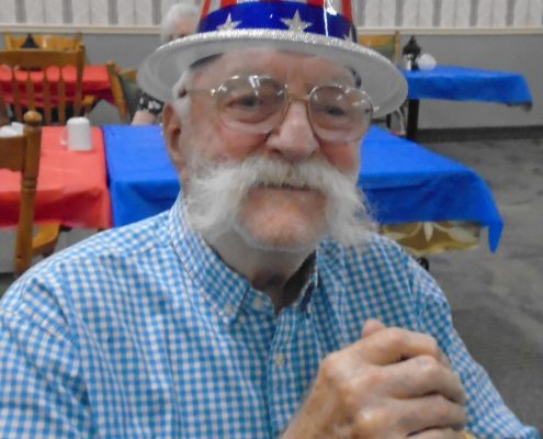 man smiling in fourth of july party hat