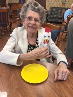 smiling wiman holding felt chicken
