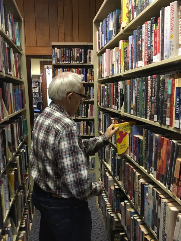man looking at bookshelf