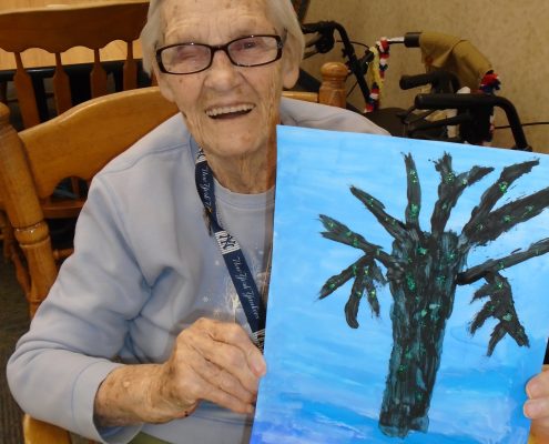 woman laughing with tree painting
