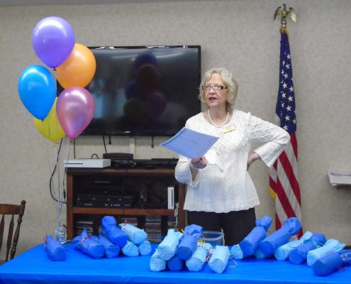 woman talking to group with gift table