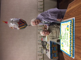 couple smiling with birthday cake