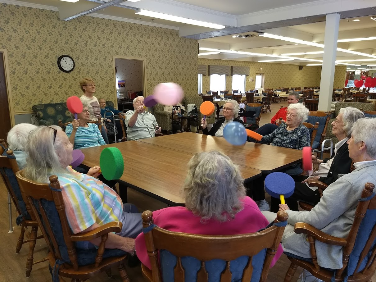 group in circle playing balloon pong