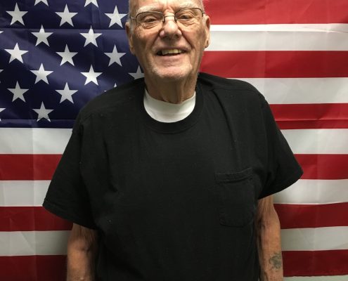 man smiling in front of american flag