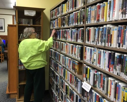 woman searcing bookshelf