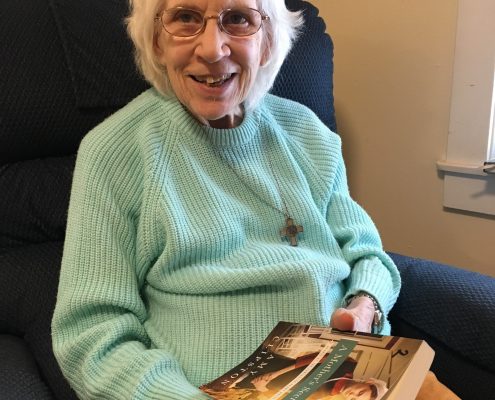 woman reading and smiling at camera